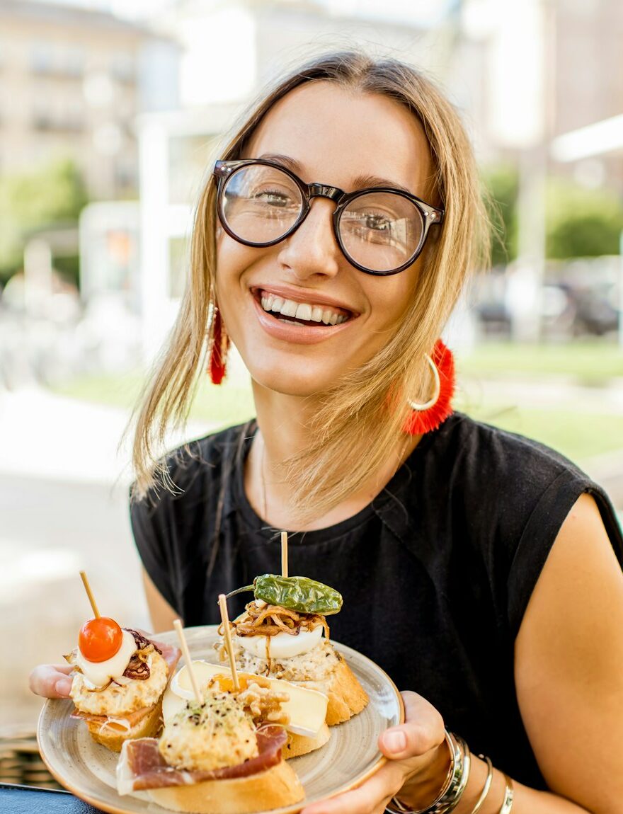 Woman eating spanish pinchos at the bar outdoors